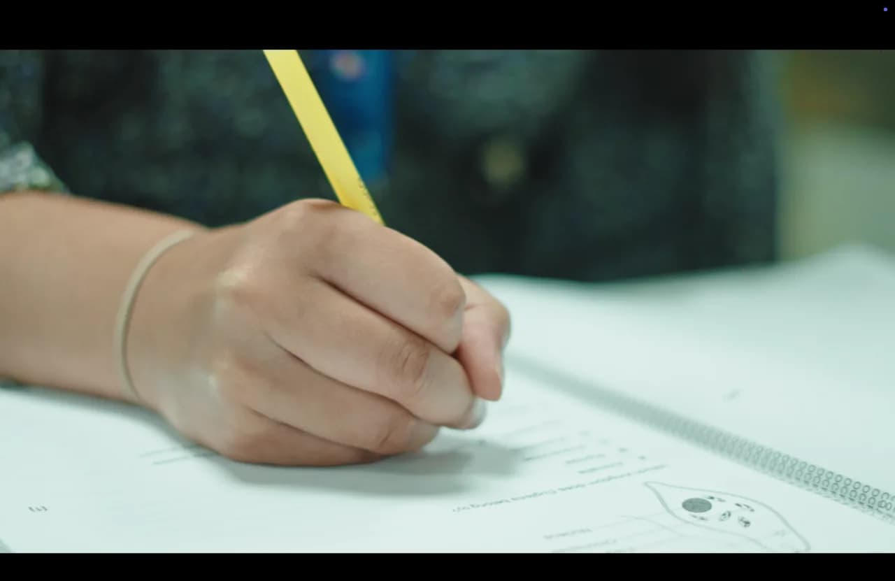 An A-Level physics student working through equations at Excel Tutors